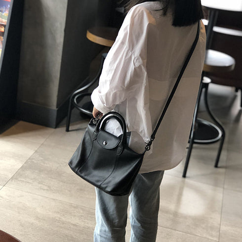 Black RockCow TS923 top-handle handbag carried beside a light blouse and blue jeans
