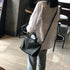 Black RockCow TS923 top-handle handbag carried beside a light blouse and blue jeans