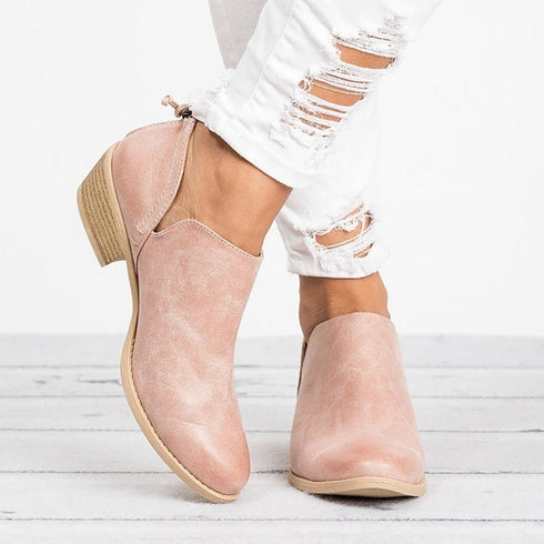 Pink ankle boots worn with white distressed jeans