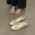 Beige round-toe ballet flats with small front bows