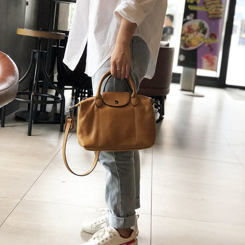 Brown RockCow TS923 handbag carried by the handles with the long strap hanging down