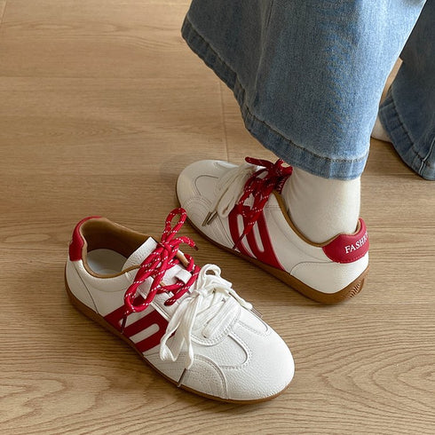 White-and-red lace-up sneakers showing rounded toes and side panels