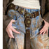Brown Western medallion belt worn with blue jeans and a white top