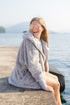 Pretty Rugged Grey faux fur hooded cardigan worn open by a lakeside seating area