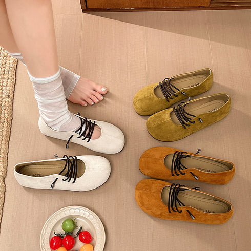 Beige lace-up flats worn with white socks beside green and brown pairs