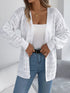 White crochet-knit cardigan, close front view showing ribbed cuffs