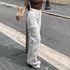 White cargo pants worn with a dark cropped top outdoors