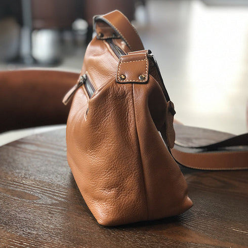 Side view of brown leather bag showing strap attachment