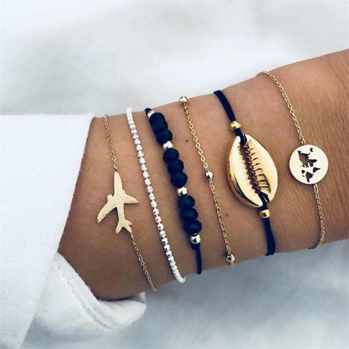 Navy and gold-tone bracelets with airplane, shell-shaped and globe charms