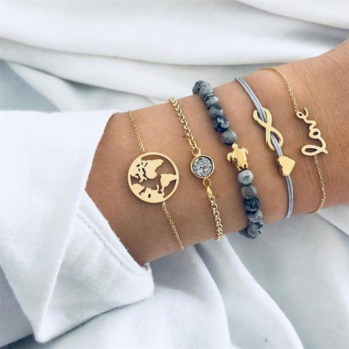Gold-tone bracelet stack with gray beads, globe and infinity details