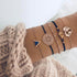 Rose-tone charm bracelets with navy accents, triangle and round openwork details