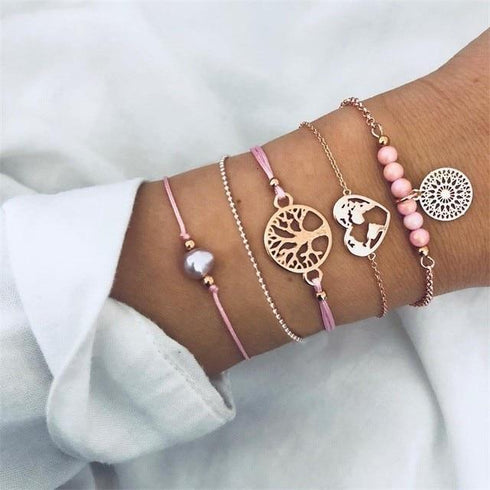 Pink and rose-tone charm bracelet stack with globe and tree details