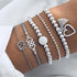 Silver-tone bracelet stack with heart, geometric and sun-shaped charms