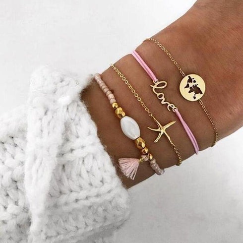 Pink and gold-tone bracelet stack with love, starfish-shaped and globe details