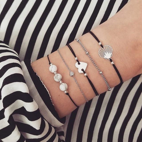 Silver-tone cord and beaded stack with puzzle and shell-shaped charms