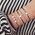 Silver-tone cord and beaded stack with puzzle and shell-shaped charms