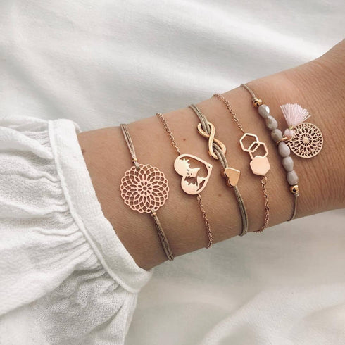 Rose-tone charm stack with gray beads, infinity and openwork circles
