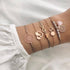 Rose-tone charm stack with gray beads, infinity and openwork circles