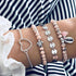 Pink bead and silver-tone stack with feather and turtle-shaped charms
