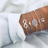 Silver-tone bracelet stack with infinity, hand-shaped and globe charms