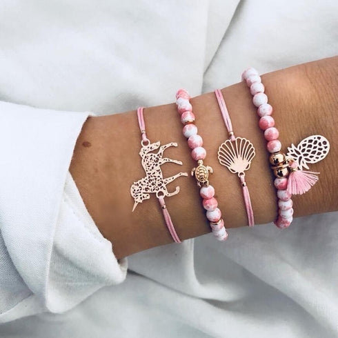 Pink bead bracelet stack with elephant and shell-shaped charms