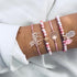 Pink bead bracelet stack with elephant and shell-shaped charms