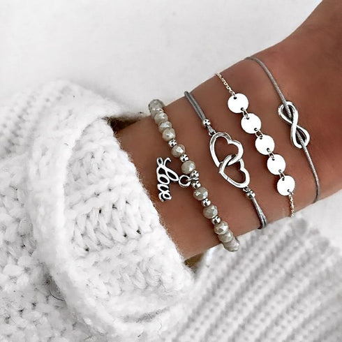 Gray bead bracelet stack with silver-tone linked circles, infinity and love charm