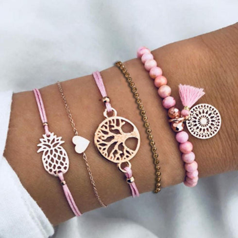Pink beaded and cord bracelets with tree and pineapple-shaped charms