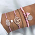 Pink beaded and cord bracelets with tree and pineapple-shaped charms