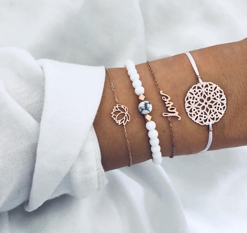 White bead and gold-tone stack with love and round openwork centerpiece