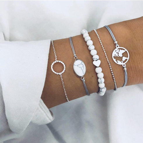White bead and silver-tone bracelets with circular and globe charms
