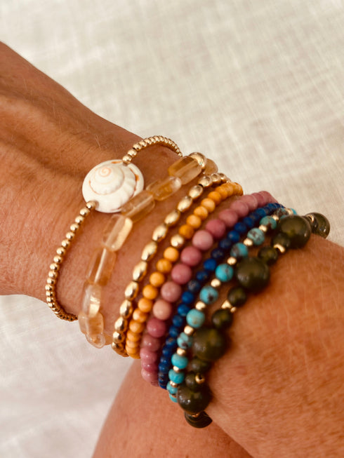 CanyonLeaf conch-shell bracelet worn beside colorful beaded bracelets