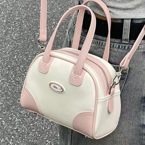 Mini Boston bag showing pink twin handles and cream panels
