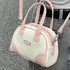 Mini Boston bag showing pink twin handles and cream panels