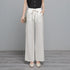 White high-waisted wide-leg pants worn with a black sleeveless top