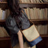 Beige and navy color-block shoulder bag worn over a dark blouse