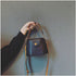 Black mini bucket bag held by its short handle