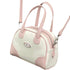 Pink-and-white mini bowling bag with long crossbody strap on white