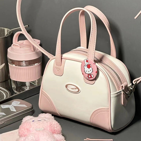 Pink-trim mini bowling bag styled with a charm and drinkware