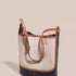 Beige canvas shoulder bag with navy base and brown trim on neutral background