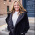 Front view of Black Pretty Rugged faux fur cardigan with hands in the side pockets