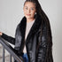 Black Pretty Rugged cardigan worn with the smooth satin side facing outward and faux fur at the collar