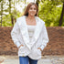 White Pretty Rugged faux fur cardigan worn open outdoors with blue jeans