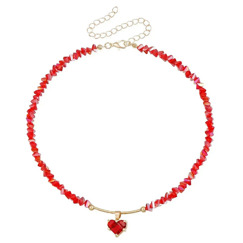 Red irregular bead necklace with red heart pendant and gold-tone fittings, on white