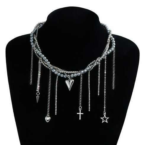 Dark layered necklace with heart and other charm drops displayed on a black bust