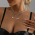 Pale beaded necklace with dangling silver-tone chains and small heart charms, modeled