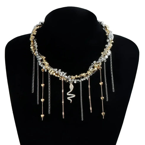 Gold-tone and silver-tone layered necklace with snake-shaped center charm, on black bust