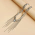 Silver-tone beaded fringe necklace laid diagonally across a beige prop