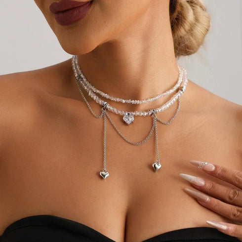 Layered beaded heart necklace with hanging drops, angled neckline close-up