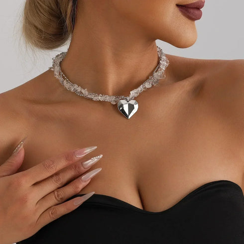 Clear-look bead necklace with a large faceted-look heart pendant, modeled close-up